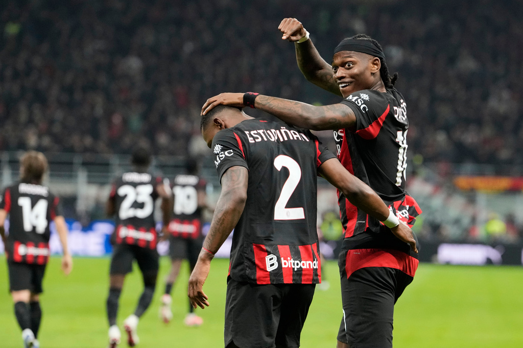 AC Milan's Pervis Estupinan, centre, celebrates with Rafael Leao after scoring the opening goal during the Serie A soccer match between AC Milan and Inter Milan, in Milan, Italy, Sunday, March 8, 2026. (AP Photo/Luca Bruno)