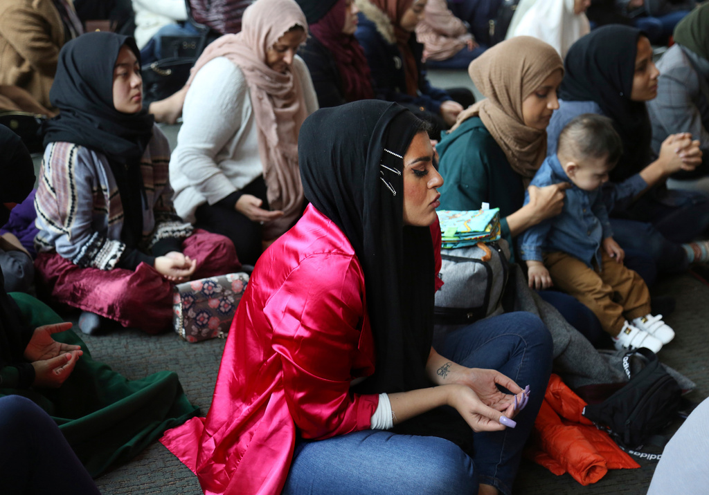 FILE - In this Dec. 27, 2019 file photo, Amani Al-Khatahtbeh, center, sits near the back of the room at the Islamic Center of New York University during Friday prayers. (AP Photo/Jessie Wardarski, File)