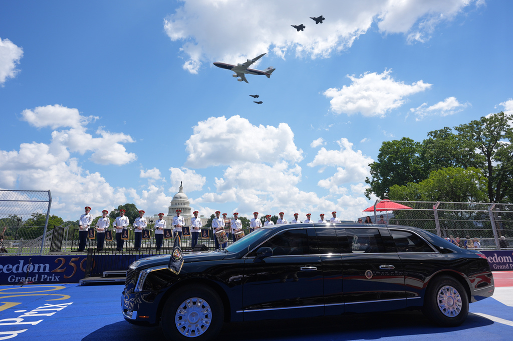 Air Force One and four F-35's pass over as President Donald Trump, in the presidential limousine known as "The Beast," does a lap around the track before the IndyCar Freedom 250 Grand Prix auto race in Washington, Sunday, Aug. 23, 2026. (AP Photo/Alex Brandon)