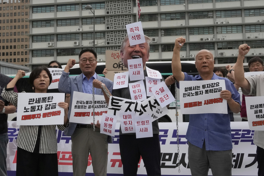 A protester wearing a mask of U.S. President Donald Trump attends a rally against the detention of South Korean workers during an immigration raid in Georgia, near the U.S. Embassy in Seoul, South Korea, Tuesday, Sept. 9, 2025. The part of letters read "Immediate releases and Trump apology." (AP Photo/Ahn Young-joon)