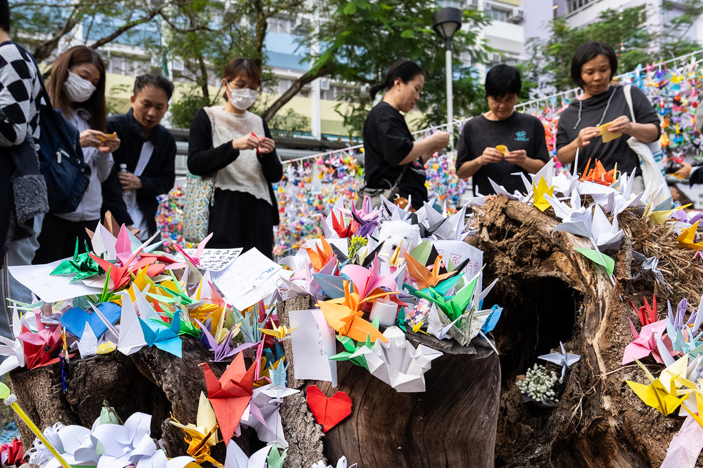 People place paper cranes near the site of the fire at Wang Fuk Court, a residential estate in the Tai Po district of Hong Kong's New Territories on Wednesday, Dec 3, 2025. (AP Photo/Chan Long Hei)