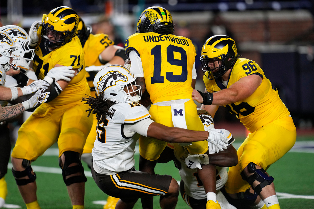 Western Michigan defensive end Kedrick Burley (15) sacks Michigan quarterback Bryce Underwood (19) during the first half of an NCAA college football game Saturday, Sept. 5, 2026, in Ann Arbor, Mich. (AP Photo/Paul Sancya)