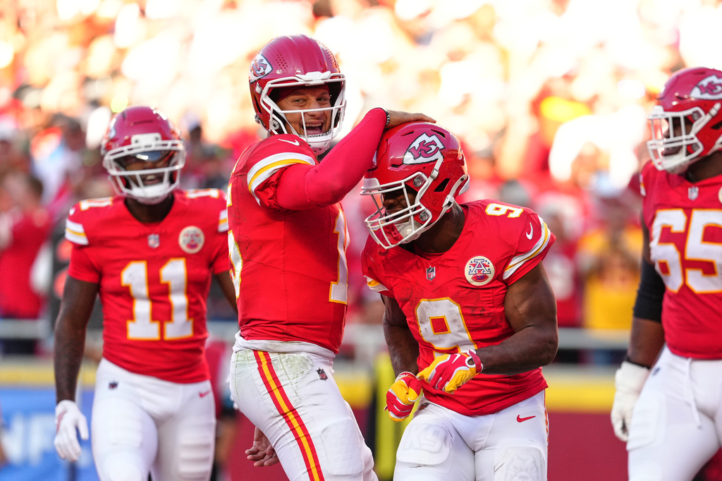 Kansas City Chiefs quarterback Patrick Mahomes, center left, and Kenneth Walker III (9) celebrate a touchdown scored on a rushing play by Walker III during the first half of an NFL football game against the Los Angeles Chargers in Kansas City, Mo., Sunday, Oct. 18, 2026. (AP Photo/Ed Zurga)