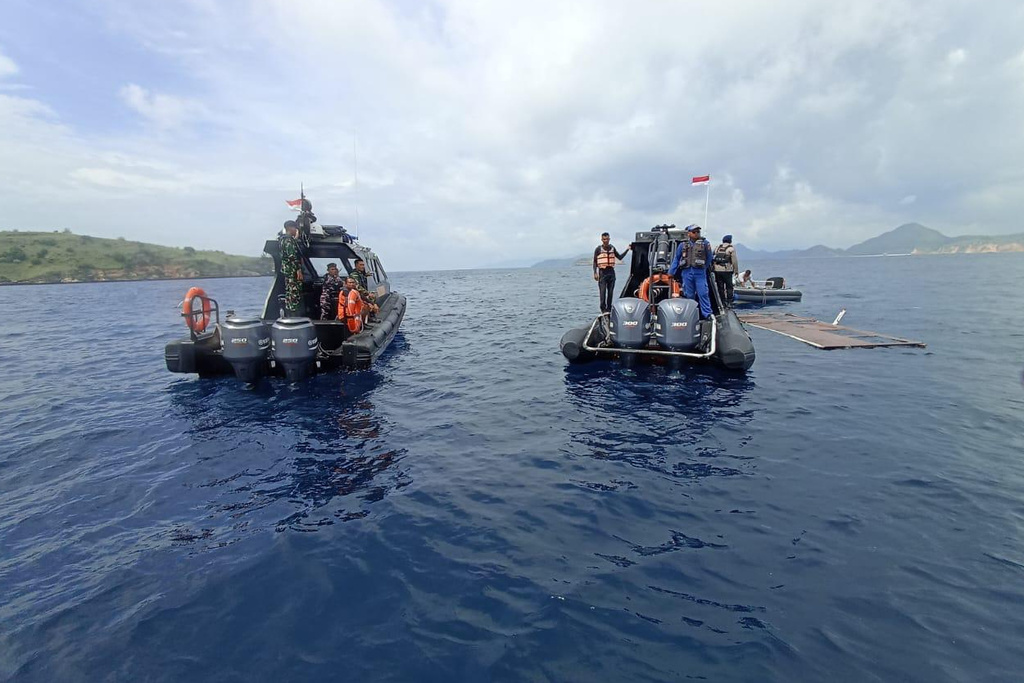 In this photo released by the Indonesian National Search and Rescue Agency (BASARNAS) on Saturday, Dec. 27, 2025, rescuers examine the waters where a debris believed to be from a tour boat that sank was found, near Padar Island within Komodo National Park, Indonesia. (BASARNAS via AP)