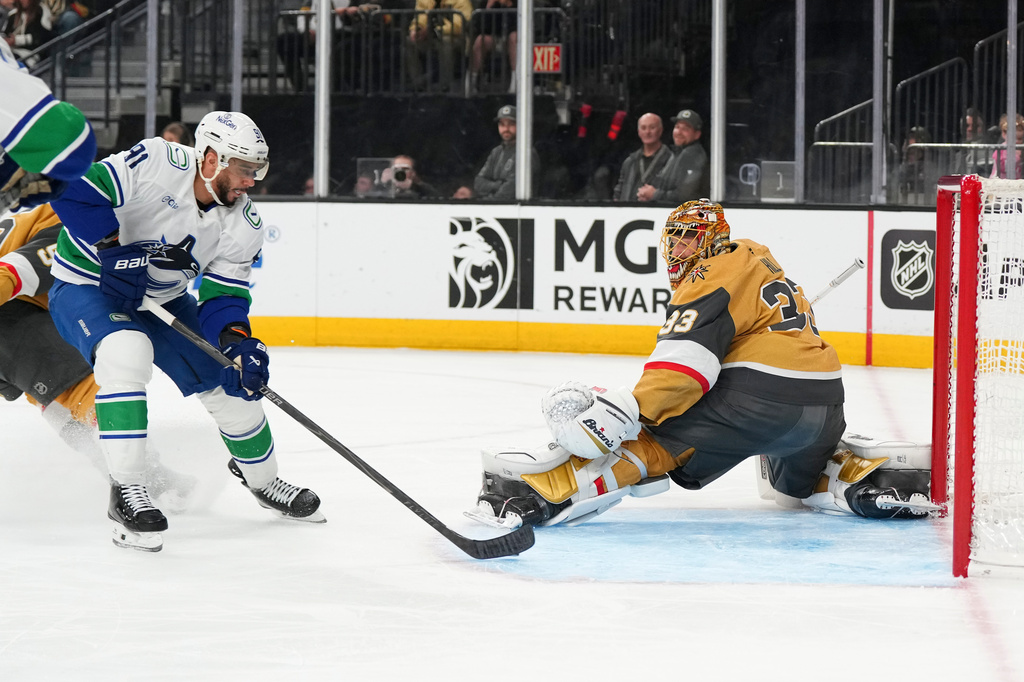 Vancouver Canucks left wing Evander Kane (91) scores against Vegas Golden Knights goaltender Adin Hill (33) during the first period of an NHL hockey game Monday, March 30, 2026, in Las Vegas. (AP Photo/Candice Ward)