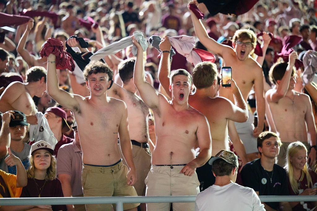 Florida State students wave their shirts during a stadium-wide power outage before an NCAA college football game against SMU, Monday, Sept. 7, 2026, in Tallahassee, Fla. (AP Photo/Noah Lantor)