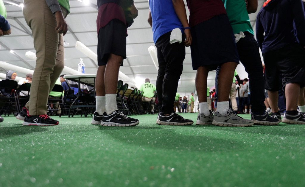 FILE - Immigrants line up in the dining hall at a new U.S. government holding center for migrant children in Carrizo Springs, Texas, on July 9, 2019. (AP Photo/Eric Gay, File)