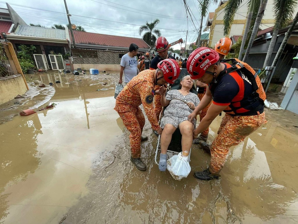 Cebu City fire station officials carry an individual after flooding caused by Typhoon Kalmaegi in Cebu city, central Philippines, Tuesday, Nov. 4, 2025. (AP Photo/Jacqueline Hernandez)