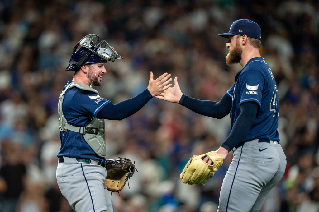 Tampa Bay Rays relief pitcher Bryan Baker, right, and catcher Liam Hicks celebrate after a baseball game against the Seattle Mariners, Saturday, Aug. 8, 2026, in Seattle. (AP Photo/Stephen Brashear)