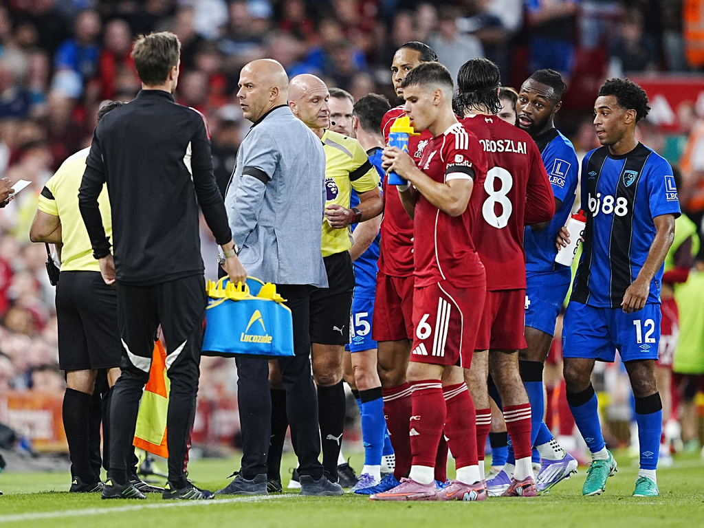 Referee Anthony Taylor during a stop in play after Bournemouth's Antoine Semenyo, second right, informs the referee of a possible racial comment from the crowd during the English Premier League soccer match between Liverpool and Bournemouth at Anfield, Liverpool, England, Friday Aug. 15, 2025. (Peter Byrne/PA via AP)