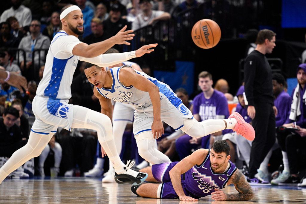 Orlando Magic guard Jalen Suggs, left, guard Desmond Bane (3) and Utah Jazz forward John Konchar (55) battle for a loose ball during the first half of an NBA basketball game, Saturday, Feb. 7, 2026, in Orlando, Fla. (AP Photo/Phelan M. Ebenhack)