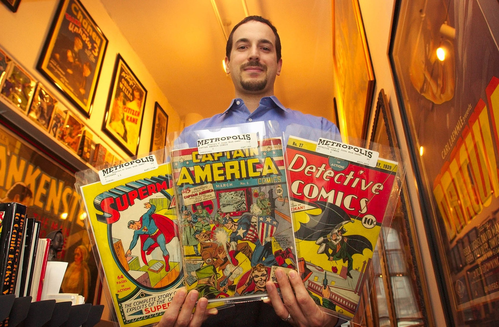 File - Vincent Zurzolo, co-partner of Metropolis Collectibles, holds three examples of the company's vast collection of comic books in their offices in New York, Thursday, July 10, 2003. (AP Photo/Gregory Bull, File)