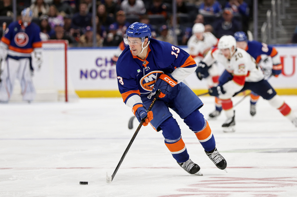 FILE - New York Islanders center Mathew Barzal (13) controls the puck in the second period of an NHL hockey game against the Florida Panthers, March 28, 2026, in Elmont, N.Y. (AP Photo/Adam Hunger, File)