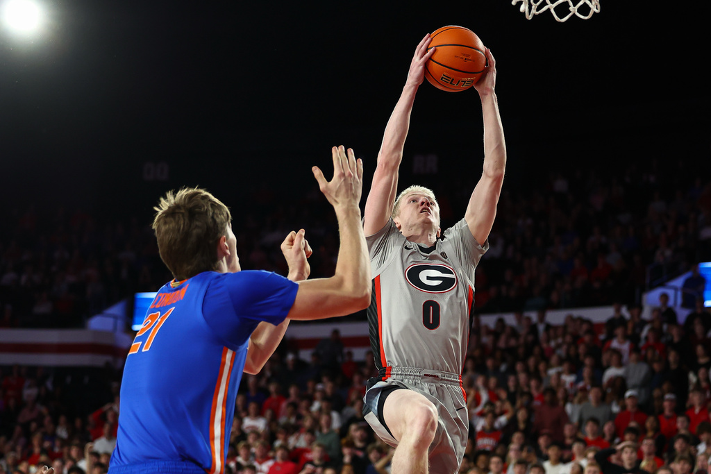 Georgia guard Blue Cain (0) shoots against Florida forward Alex Condon, left, during the first half of an NCAA college basketball game, Wednesday, Feb. 11, 2026, in Athens, Ga. (AP Photo/Colin Hubbard)