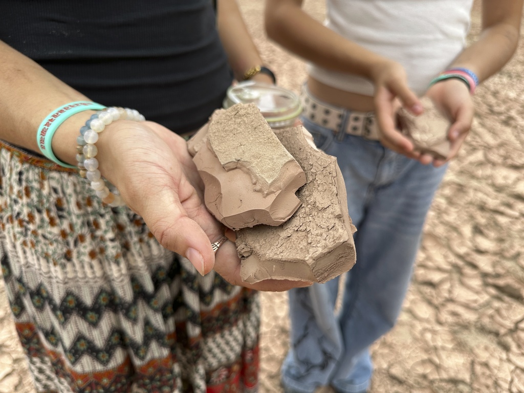 Sisters Zoe Hughes and Phoebe Hughes hold pieces of clay collected from the dry Rio Grande in Albuquerque, N.M., on Thursday, Aug. 21, 2025. (AP Photo/Susan Montoya Bryan)