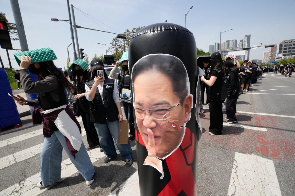 Members of the Samsung Electronics labor union pass by a balloon showing a photo of Samsung Electronics Chairman Lee Jae-yong as they arrive to attend a rally demanding higher bonuses at its computer chip complex in Pyeongtaek, South Korea, Thursday, April 23, 2026. (AP Photo/Ahn Young-joon)