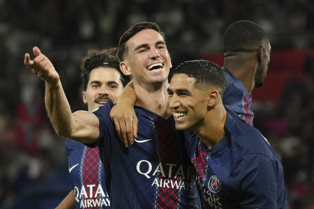 PSG's Fabian Ruiz, center, reacts after score his side opening goal with PSG's Achraf Hakimi, right, during the League One soccer match Paris Saint-Germain against Angers at the Parc des Princes stadium, Friday, Aug. 22, 2025 in Paris. (AP Photo/Aurelien Morissard)