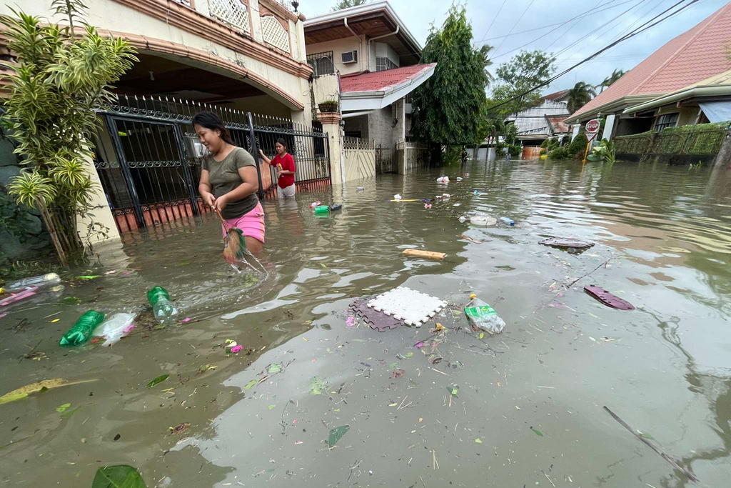 Residents walk outside their flooded homes as Typhoon Kalmaegi affects Cebu city, central Philippines, Tuesday Nov. 4, 2025. (AP Photo/Jacqueline Hernandez)