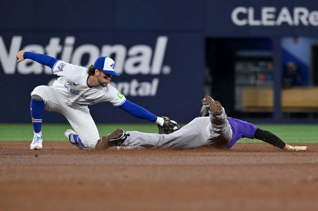 Toronto Blue Jays infielder Ernie Clement (22) tags out Colorado Rockies outfielder Hunter Goodman (15) on an attempted stolen base to end the fifth inning of interleague baseball in Toronto, Monday, March 30, 2026. (Jon Blacker/The Canadian Press via AP)