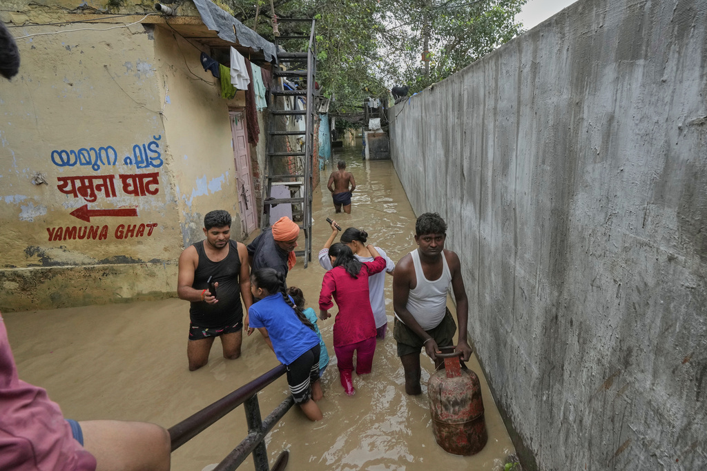 Residents wade through floodwater after the river Yamuna, swollen by incessant rain in the higher regions, overran its banks, in New Delhi, India, Tuesday, Sept. 2, 2025. (AP Photo/Manish Swarup)