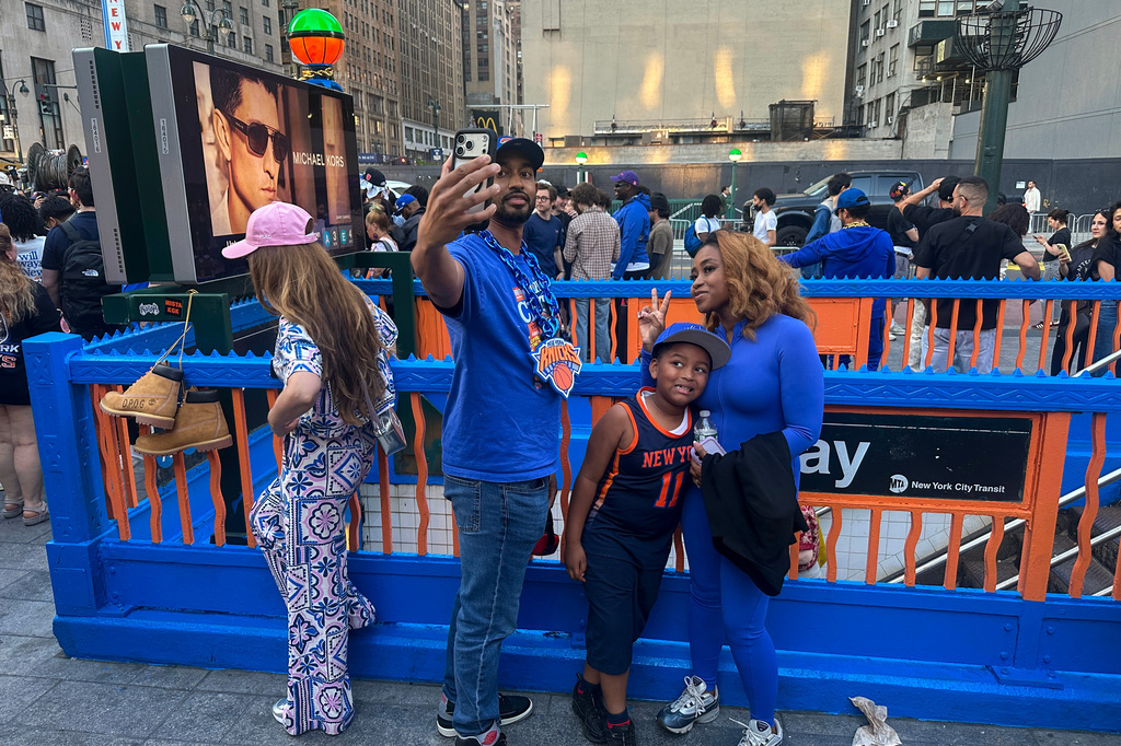 New York Knicks fans pose at a subway entrance in New York decorated in team colors as the Knicks play the San Antonio Spurs in Game 1 of the NBA Finals basketball series on Wednesday, June 3, 2026. (AP Photo/Ted Shaffrey)