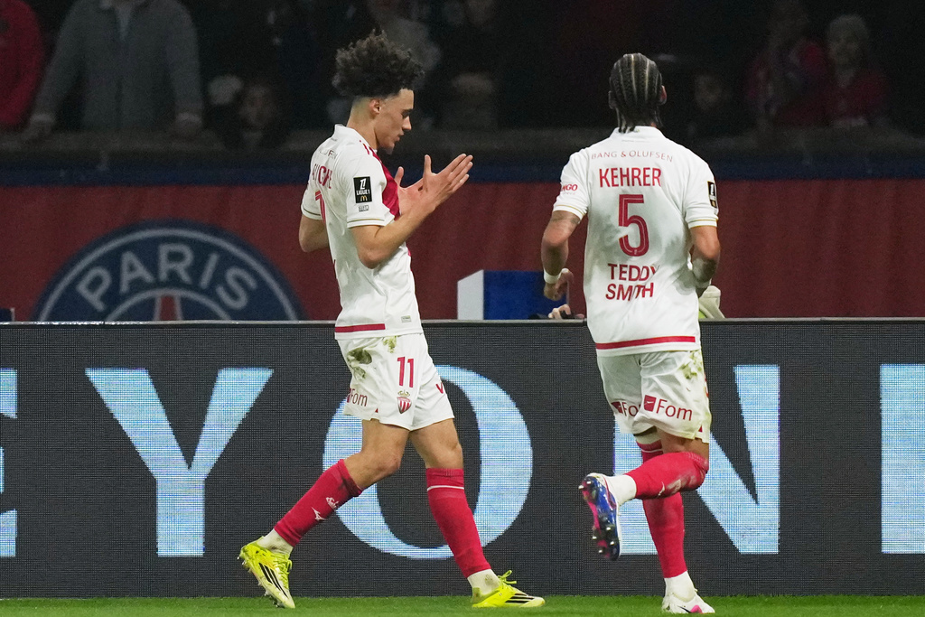 Monaco's Maghnes Akliouche, left, celebrates scoring his side's opening goal during the French League One soccer match between Paris Saint-Germain and Monaco in Paris, Friday, March 6, 2026. (AP Photo/Thibault Camus)