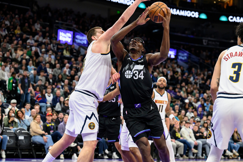 Utah Jazz center Oscar Tshiebwe (34) drives to the basket while guarded by Denver Nuggets center Nikola Jokic, left, during the first half of an NBA basketball game, Monday, March 2, 2026, in Salt Lake City. (AP Photo/Tyler Tate)
