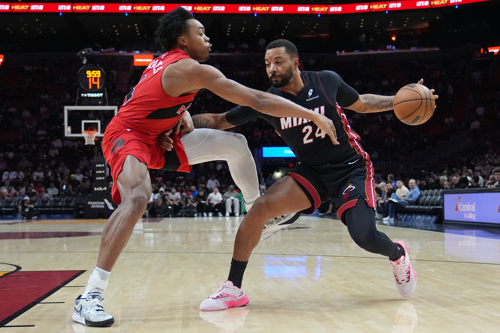 Miami Heat guard Norman Powell (24) drives to the basket as Toronto Raptors forward Scottie Barnes, left, defends during the first half of an NBA basketball game, Monday, Dec. 15, 2025, in Miami. (AP Photo/Lynne Sladky)