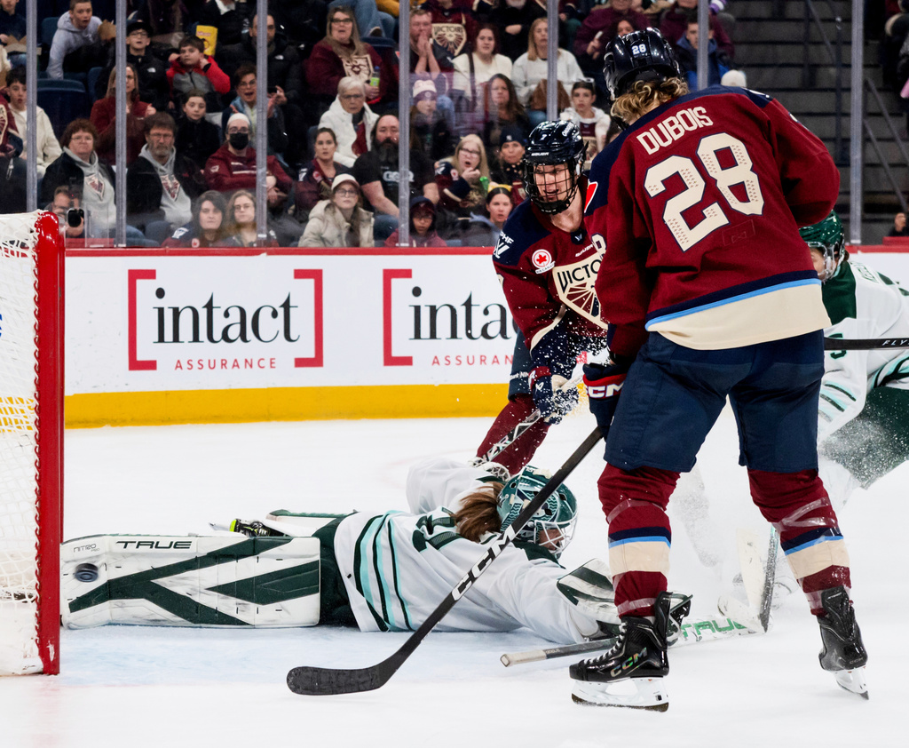 Montreal Victoire's Laura Stacey (7) and Catherine Dubois (28) watch as the puck shot by teammate Victoire's Abby Roque (not shown) sails past Boston Fleet goaltender Aerin Frankel, left, during second-period PWHL hockey game action in Laval, Quebec, Sunday March 15, 2026. (Peter McCabe/The Canadian Press via AP)