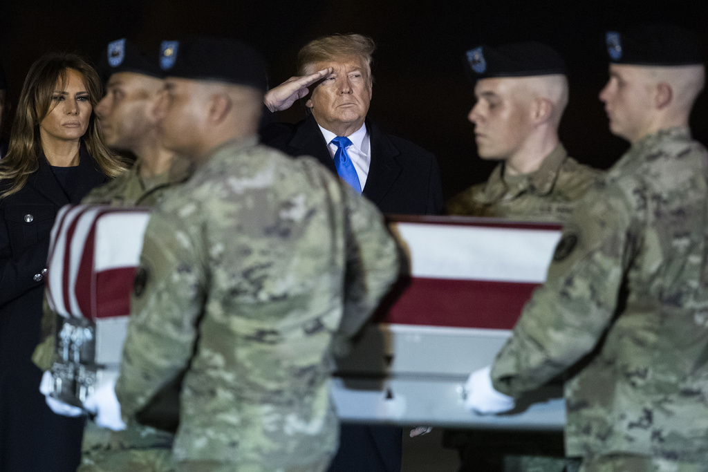 FILE - President Donald Trump and first lady Melania Trump watch as a U.S. Army carry team moves a transfer case containing the remains of Chief Warrant Officer 2 David C. Knadle, of Tarrant, Texas, Nov. 21, 2019, at Dover Air Force Base, Del. (AP Photo/Matt Rourke, file)
