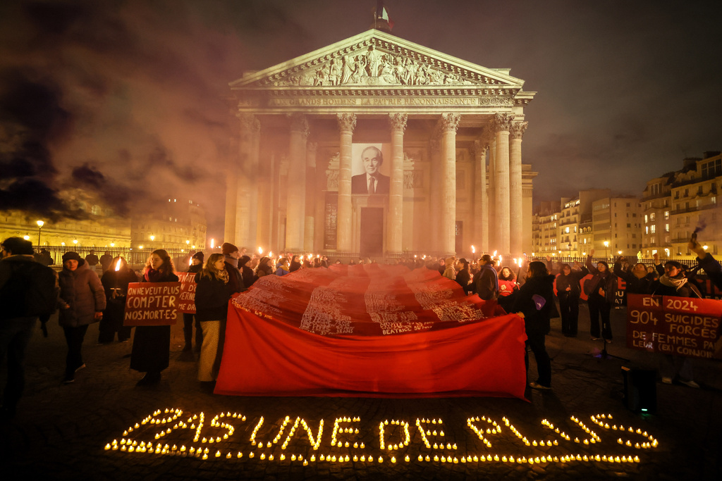 Women hold a banner in front of the Pantheon to mark the international day for the elimination of violence against women, in Paris, France, Tuesday, Nov. 25. 2025. (AP Photo/Thomas Padilla)