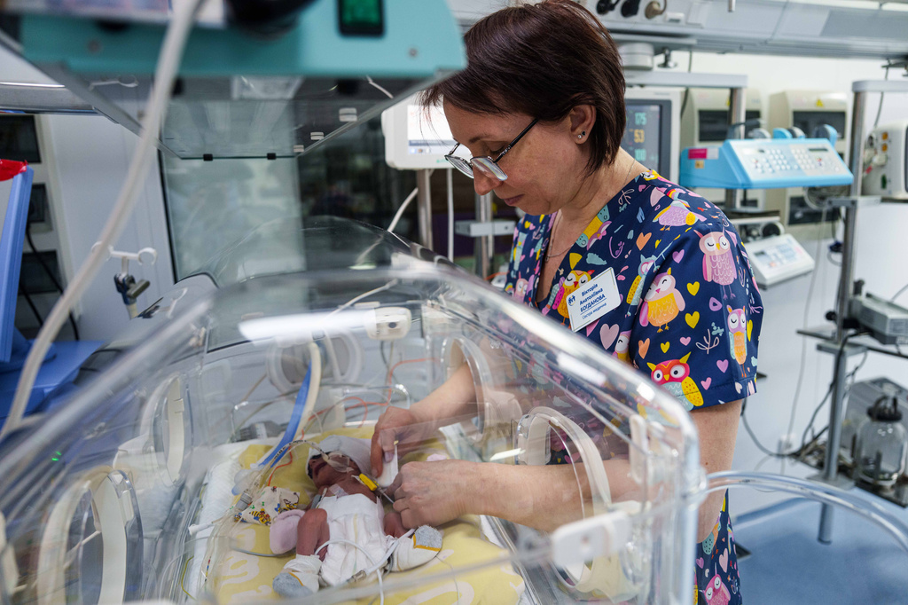 Nurse Victoria Bohdanova changes the diaper of a premature baby inside a temperature-controlled incubator at the regional perinatal center of Zaporizhzhia, Ukraine, Wednesday, May 6, 2026. (AP Photo/Evgeniy Maloletka)