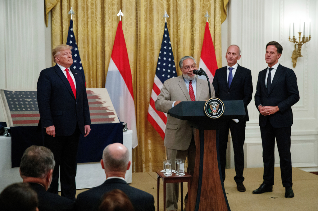 FILE - Lonnie Bunch, the New Secretary of the Smithsonian, joined by President Donald Trump, left, Dutch collector Bert Kreuk, second from right, and Dutch Prime Minister Mark Rutte, right, speaks during a ceremony in the East Room of the White House, July 18, 2019, in Washington. (AP Photo/Carolyn Kaster, File)