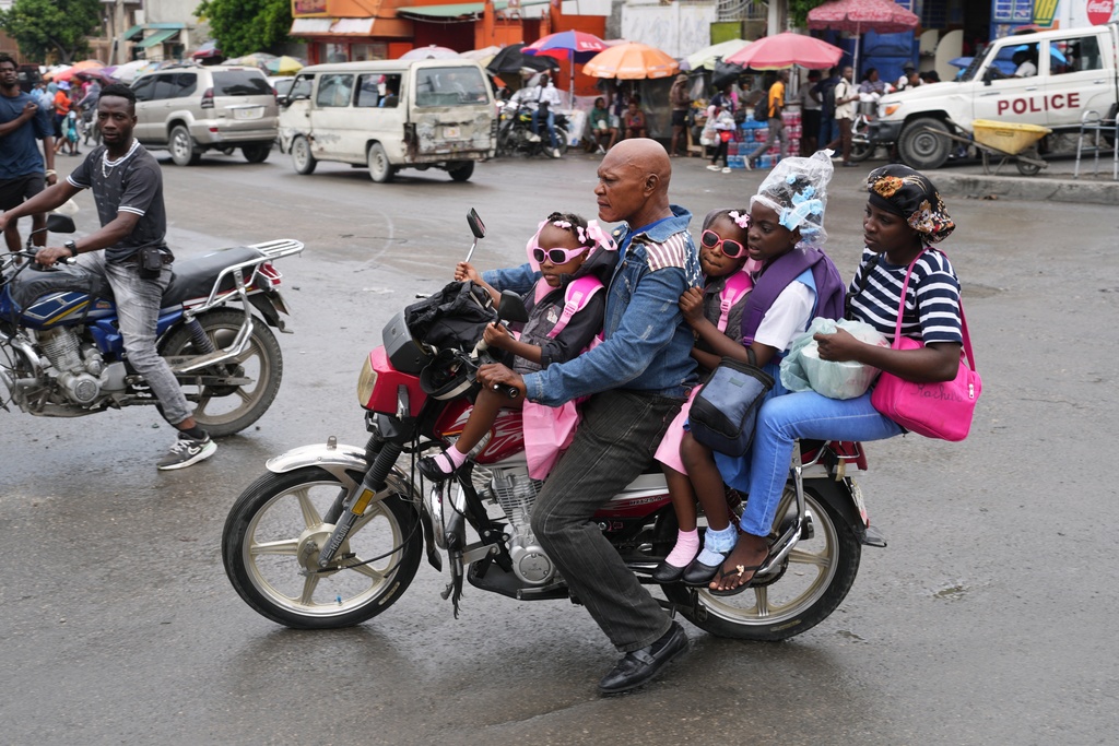 FILE - A moto-taxi driver transports clients in Port-au-Prince, Haiti, Oct. 23, 2025. (AP Photo/Odelyn Joseph)