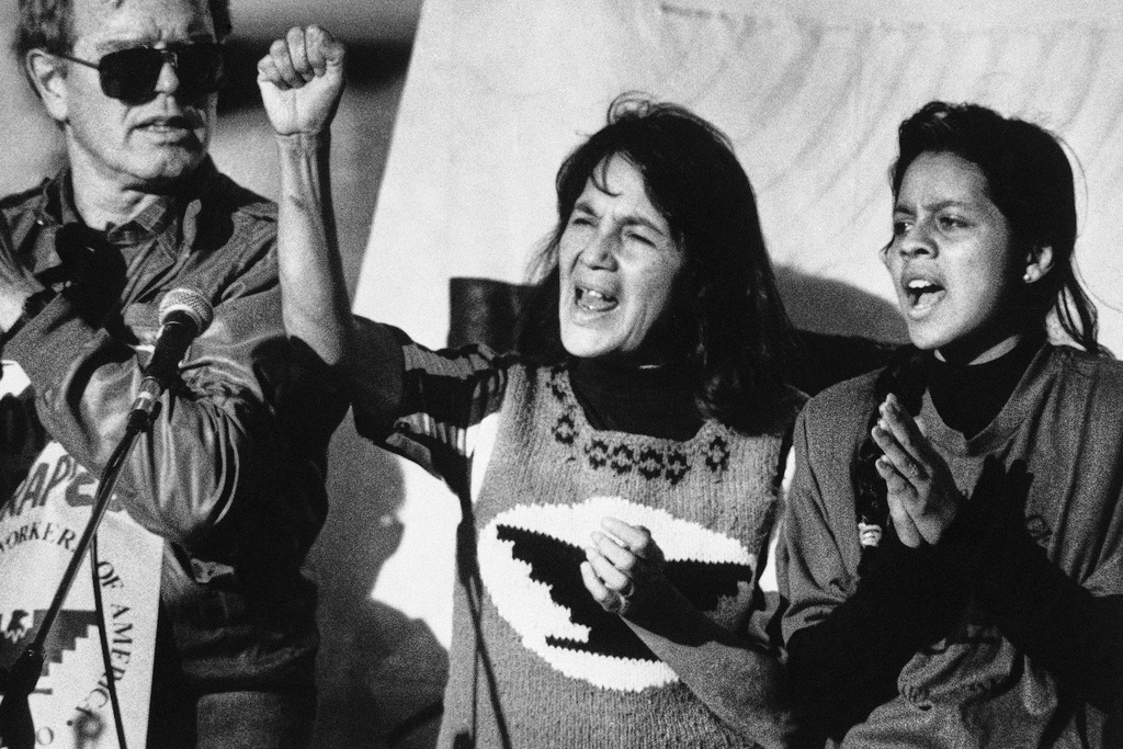 FILE - United Farm Workers leader Dolores Huerta, center, leads a rally in San Francisco's Mission District on Nov. 19, 1988, along with Howard Wallace, president of the San Francisco chapter of the UFW, left, and Maria Elena Chavez, 16, the daughter of Cesar Chavez, right, as part of a national boycott of what the UFW claims is the dangerous use of pesticides on table grapes. (AP Photo/Court Mast, File)