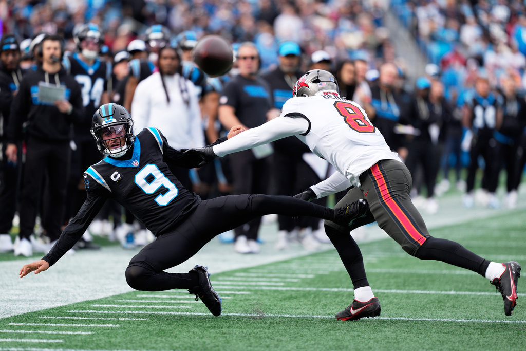 Carolina Panthers quarterback Bryce Young passes under pressure from Tampa Bay Buccaneers linebacker Sirvocea Dennis during the first half of an NFL football game, Sunday, Dec. 21, 2025, in Charlotte, N.C. (AP Photo/Jacob Kupferman)