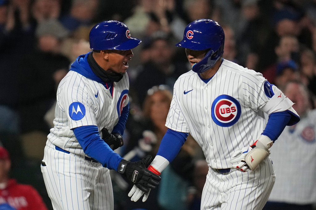 Chicago Cubs' Seiya Suzuki, right, celebrates with third base coach Quintin Berry after hitting a two-run home run during the fifth inning of a baseball game against the Philadelphia Phillies, Wednesday, April 22, 2026, in Chicago. (AP Photo/Erin Hooley)
