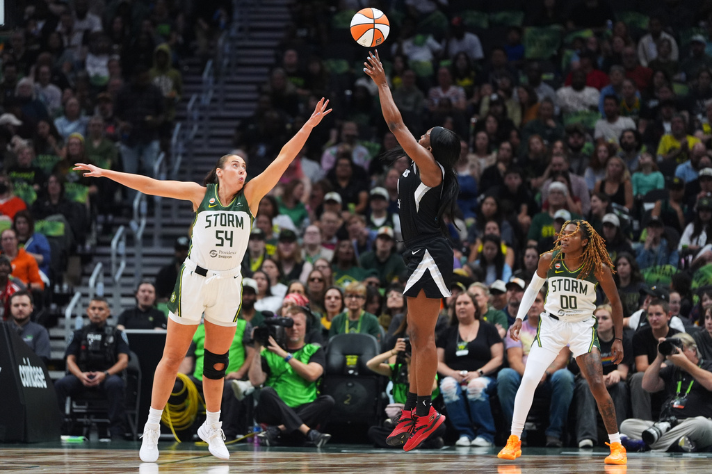 Las Vegas Aces guard Jackie Young jumps to make a basket against Seattle Storm forward Mackenzie Holmes (54) during the first half of a WNBA basketball game, Thursday, Sept. 17, 2026, in Seattle. (AP Photo/Lindsey Wasson)