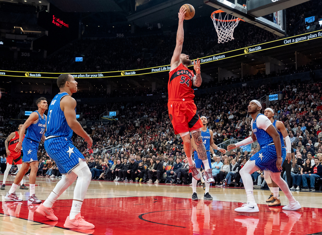 Toronto Raptors forward Sandro Mamukelashvili (54) scores between the Orlando Magic defense during first half NBA action in Toronto on Sunday, March 29, 2026. (Frank Gunn/The Canadian Press via AP)