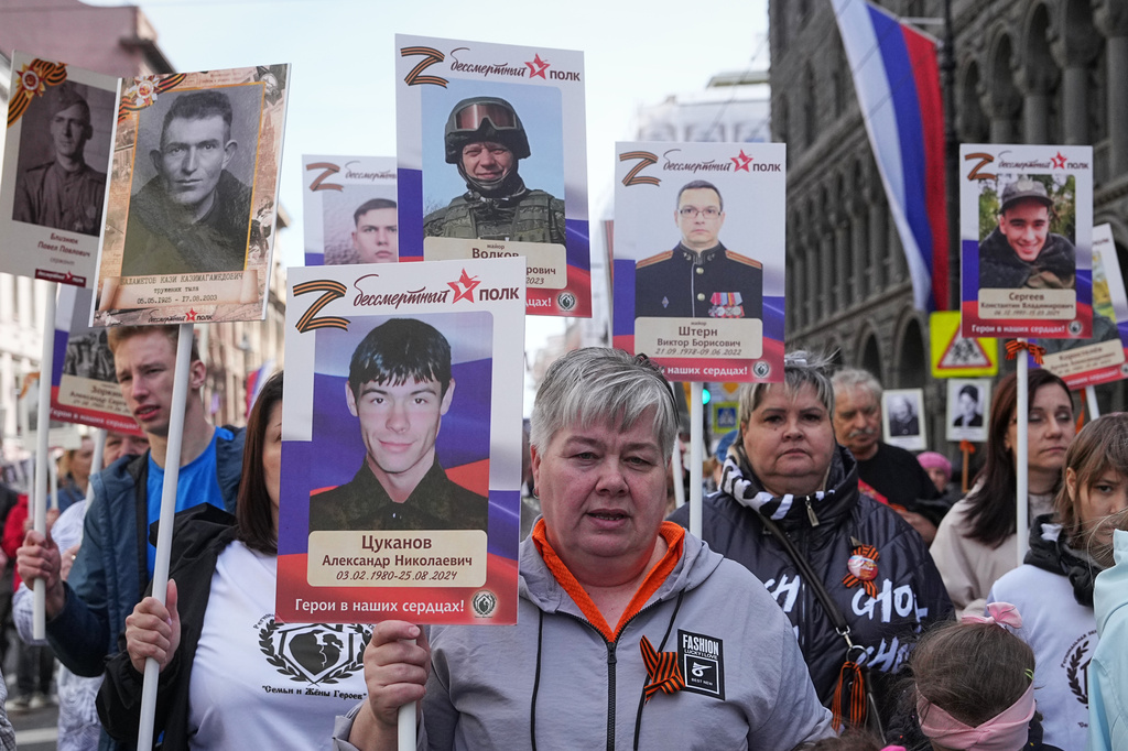 People carry portraits of their relatives, fighters, killed during military action in Ukraine, during the Immortal Regiment march at the Nevsky prospect, the central avenue of St. Petersburg, Russia, Saturday, May 9, 2026, during celebrations of the 81st anniversary of the Soviet Union's victory over Nazi Germany during the World War II. (AP Photo/Dmitri Lovetsky)