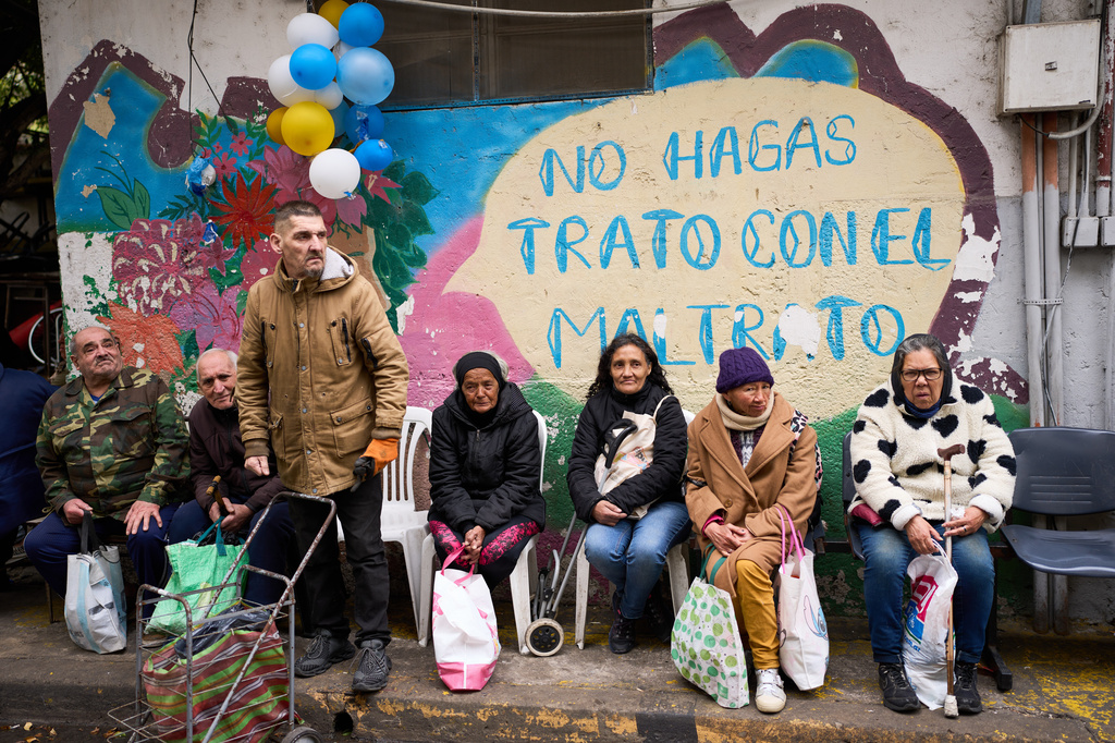 People wait to receive a free meal distributed by the Union of Workers of the Popular Economy in Buenos Aires, Argentina, Wednesday, Sept. 23, 2026. (AP Photo/Rodrigo Abd)