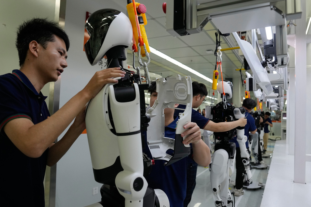 Workers assemble robot at the LY iTech Beijing Super Factory for Embodied Artificial Intelligence during a media tour in the Beijing E-Town on the outskirts of Beijing on May 29, 2026. (AP Photo/Andy Wong)