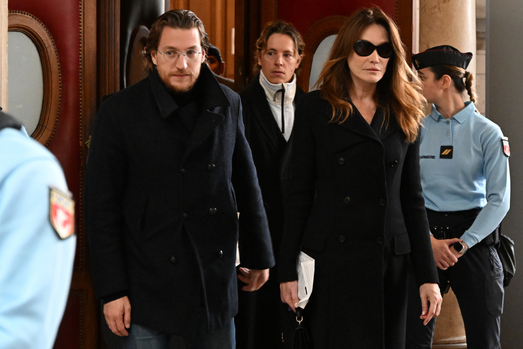 Former French President Nicolas Sarkozy's wife Carla Bruni-Sarkozy and son Jean Sarkozy leave a Paris court before it decides whether to release Sarkozy from prison, less than three weeks after he began serving a five-year sentence for criminal conspiracy in a scheme to finance his 2007 election campaign with funds from Libya, Monday, Nov. 10, 2025 in Paris. (AP Photo/Emma Da Silva)