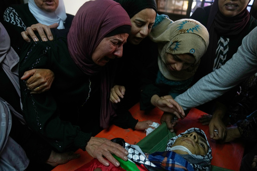Wafa Hammad, 52, left, mother of Palestinian teen Yamen Hamed, 15 who was allegedly killed by the Israeli army during overnight clashes, cries while she takes the last look at his body during his funeral in the West Bank town of Silwad Friday, Oct. 31, 2025. (AP Photo/Nasser Nasser) Wafa Hammad, 52, left, mother of Palestinian teen Yamen Hamed, 15 who was allegedly killed by the Israeli army during overnight clashes, cries while she takes the last look at his body during his funeral in the West Bank town of Silwad Friday, Oct. 31, 2025. (AP Photo/Nasser Nasser)