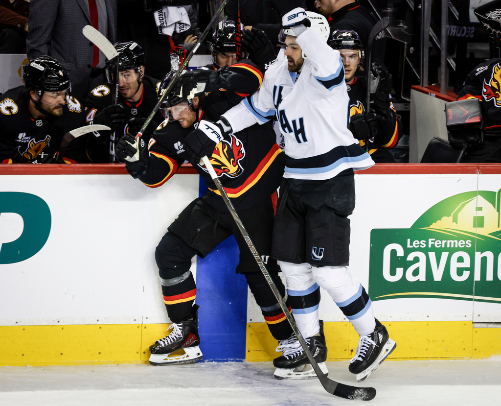 Utah Mammoth's Jack McBain, right, checks Calgary Flames' Blake Coleman during third period NHL hockey action in Calgary on Saturday, Dec. 6, 2025. (Jeff McIntosh/The Canadian Press via AP)
