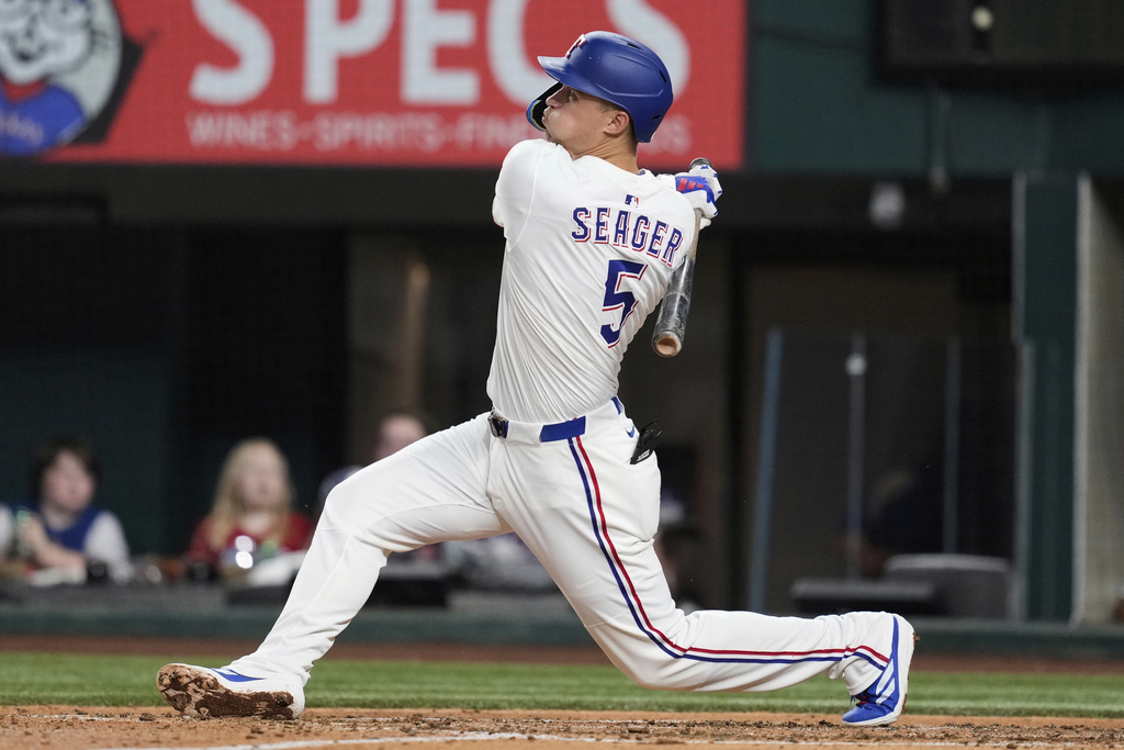 Texas Rangers shortstop Corey Seager follows through on a solo home run swing in the fourth inning of a baseball game against the Los Angeles Angels, Wednesday, Aug. 27, 2025, in Arlington, Texas. (AP Photo/Tony Gutierrez)