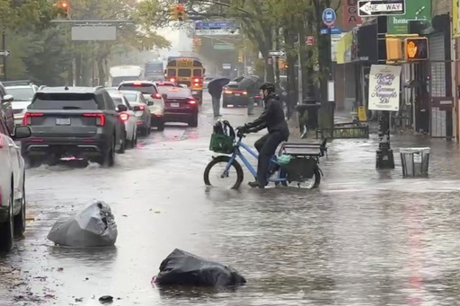 A cyclist rides through floodwaters during a rainstorm in New York, Thursday, Oct. 30, 2025. (AP Photo/David Martin) A cyclist rides through floodwaters during a rainstorm in New York, Thursday, Oct. 30, 2025. (AP Photo/David Martin)
