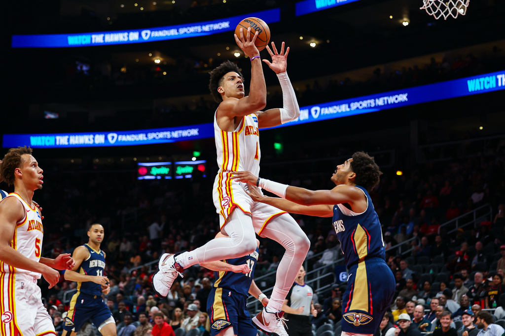 Atlanta Hawks forward Jalen Johnson, center, shoots against New Orleans Pelicans guard Jordan Poole, right, during the first half of an NBA basketball game, Wednesday, Jan. 7, 2026, in Atlanta. (AP Photo/Colin Hubbard)
