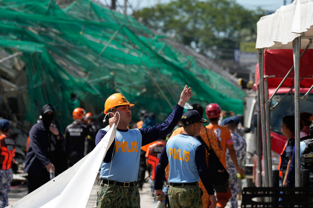 Rescuers work on a collapsed building where dozens are believed to be trapped in Angeles city in Pampanga province, north of Manila, Philippines Sunday, May 24, 2026. (AP Photo/Aaron Favila)