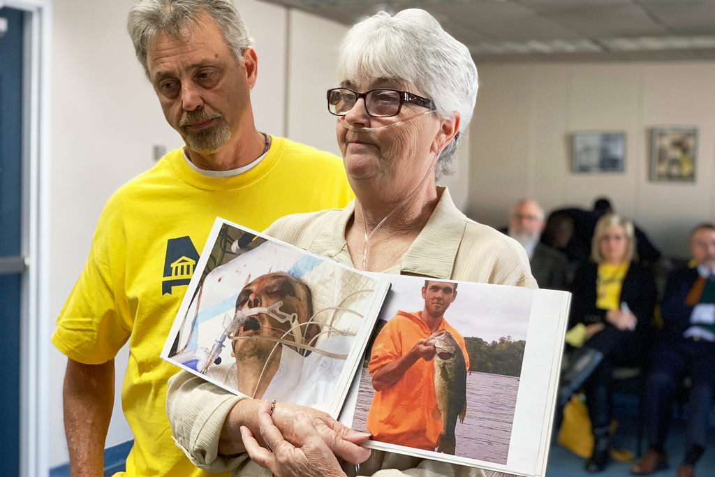 FILE - Sandy Ray holds photos of her son, Steven Davis, during a press conference at the Alabama Statehouse on Dec. 4, 2019, in Montgomery, Ala. (AP Photo/Kim Chandler, File)